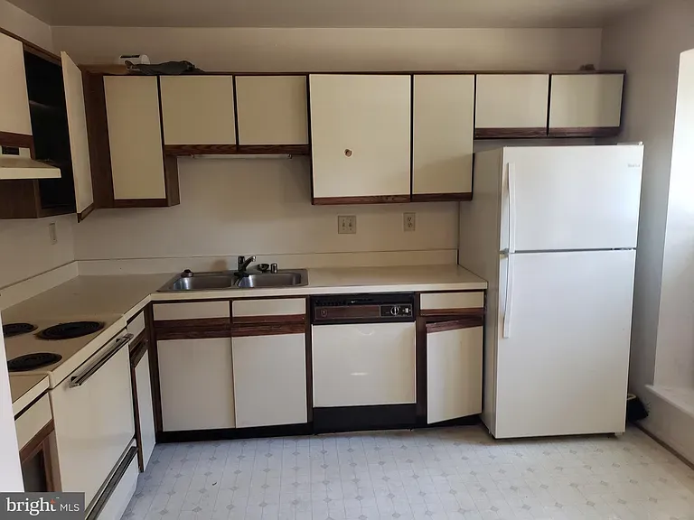 Kitchen with sink, dishwasher, refrigerator, and cabinets