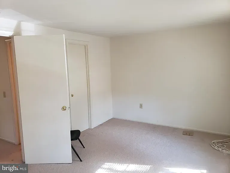 Carpeted room with a closet and open doorway