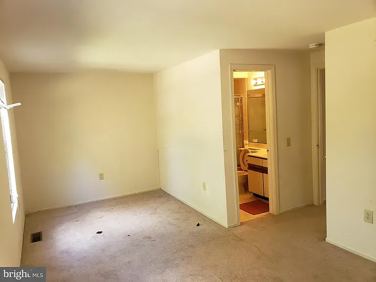 Carpeted bedroom with an adjoining bathroom