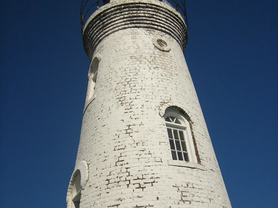 Low-angle view up the white brick lighthouse tower